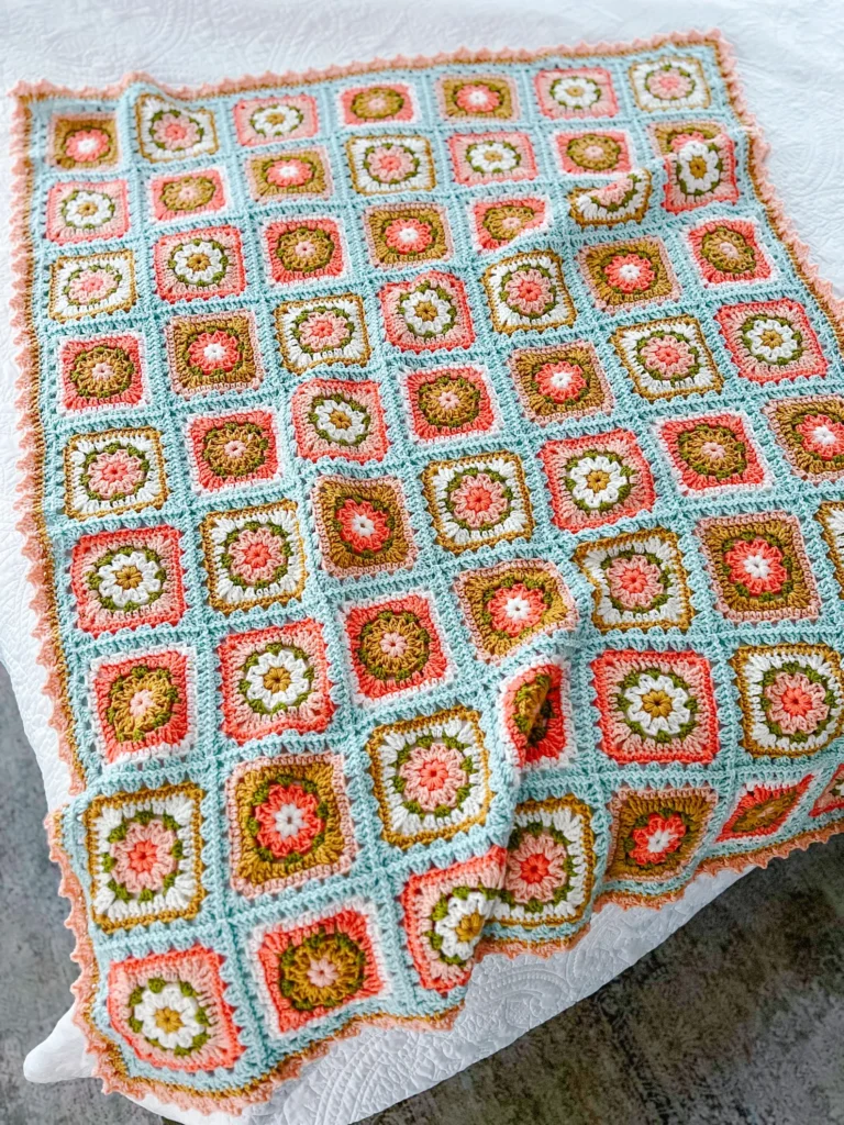 colorful granny square blanket with duck egg blue background
