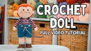 Sam Humphrey amigurumi boy doll wearing blue overalls and a red striped shirt